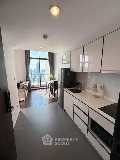 Modern open-layout kitchen with sleek cabinetry and city view from living area.