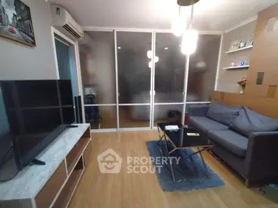 Modern living room with sleek furniture and stylish decor, featuring a large TV and cozy seating area.