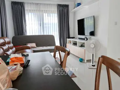 Cozy living room with modern decor, featuring a TV, sofa, and dining area, perfect for relaxation and entertainment.