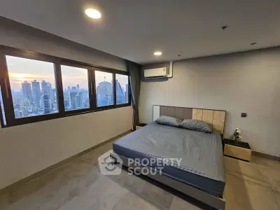 Modern bedroom with city skyline view, featuring sleek design and large windows for natural light.