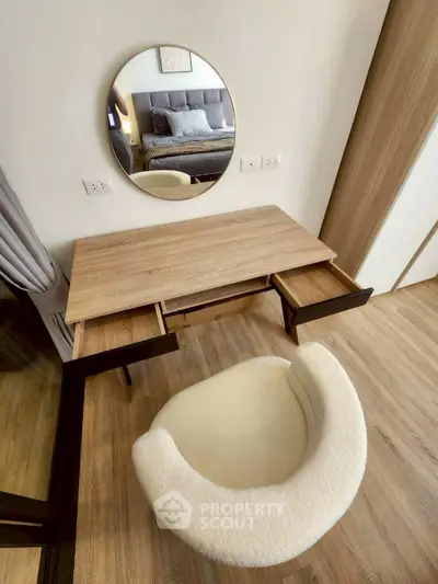 Stylish bedroom with modern vanity and cozy chair, perfect for a serene living space.