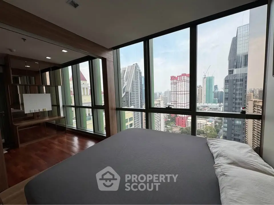 Luxurious bedroom with stunning city skyline view and floor-to-ceiling windows.