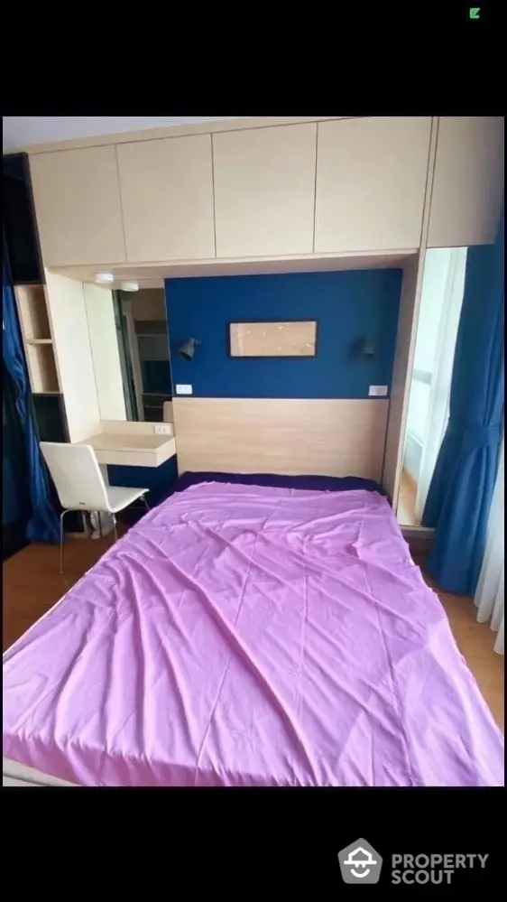 Modern bedroom with built-in storage and study desk, featuring a cozy bed with pink bedding.