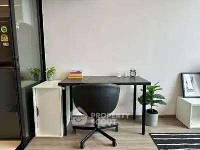 Modern study room with sleek black desk, ergonomic chair, and minimalist decor.