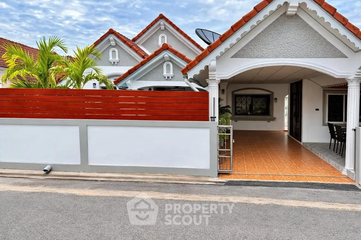 Charming suburban house with tiled porch and red roof accents, perfect for family living.