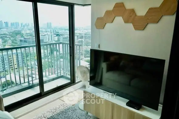 Modern living room with large TV and stunning city view from balcony.