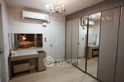 Elegant bedroom with mirrored wardrobe and chandelier lighting