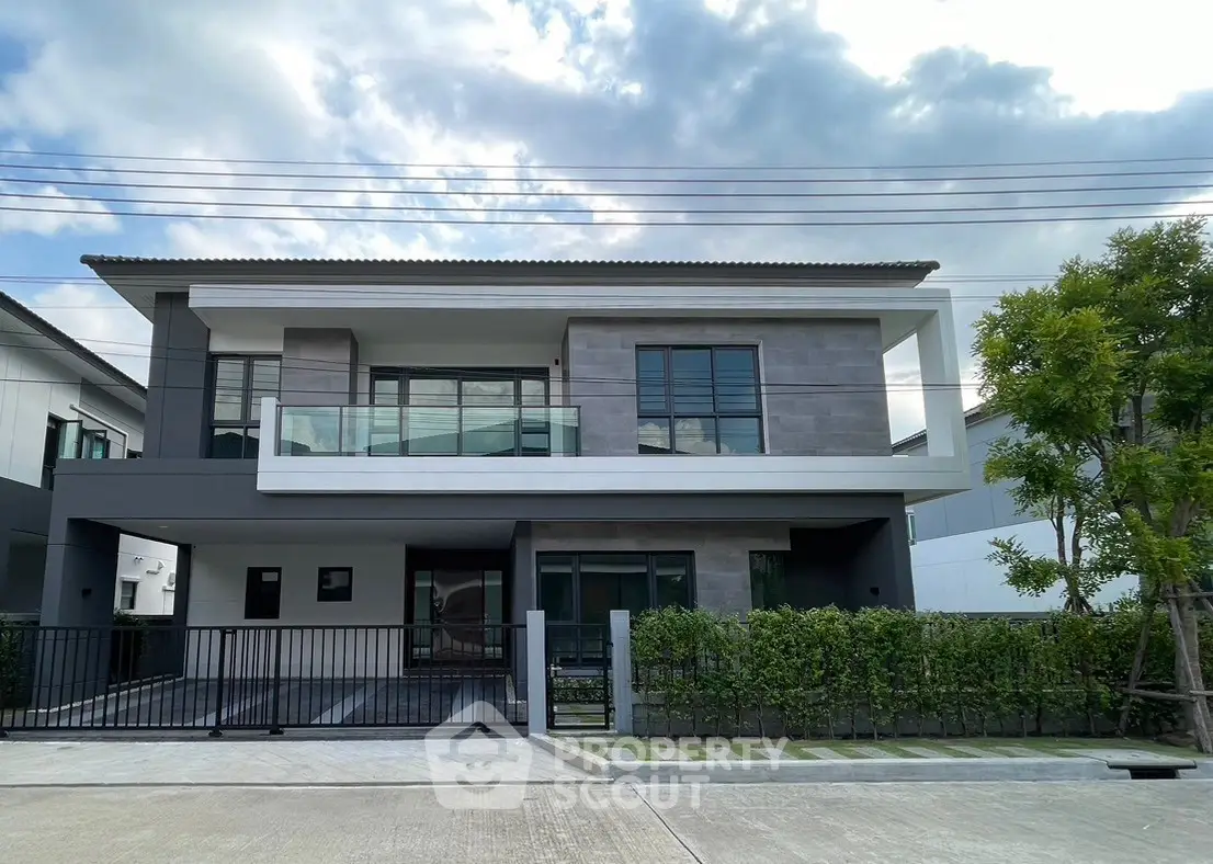 Modern two-story house with sleek design and spacious balcony in a serene neighborhood.