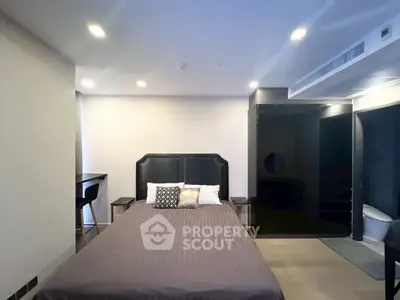 Modern bedroom with sleek design and integrated bathroom, featuring stylish furniture and ambient lighting.