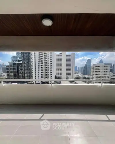 Spacious balcony with stunning city skyline view in modern high-rise building.
