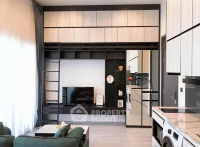 Modern living room with sleek cabinetry and integrated TV unit, featuring a cozy green sofa and stylish decor.