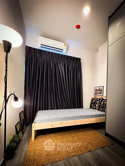 Cozy bedroom with modern decor and air conditioning, perfect for relaxation.