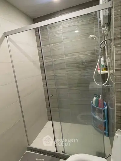 Modern bathroom with glass shower enclosure and sleek tile design.