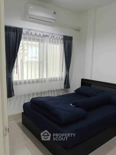 Cozy bedroom with modern air conditioning and elegant curtains, perfect for relaxation.