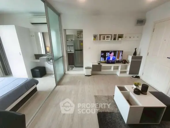 Modern studio apartment with open layout, featuring a cozy living area and sleek kitchen.