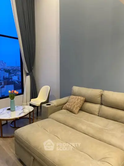 Luxurious living room with modern sofa and stunning city view through large window.