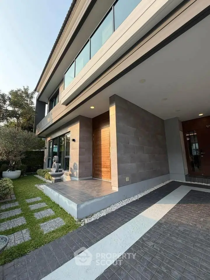 Modern two-story house with sleek exterior and landscaped garden path.