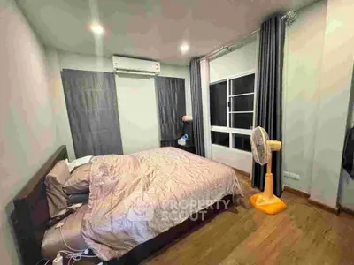 Cozy bedroom with modern decor and large windows for natural light.