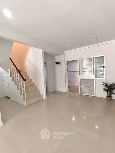 Spacious modern living room with staircase and large windows