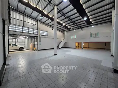 Spacious industrial warehouse with high ceilings and ample natural light, perfect for storage or manufacturing.