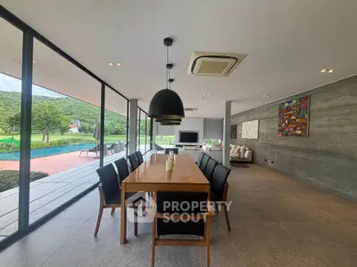 Spacious open-plan living and dining area with floor-to-ceiling windows and scenic views.