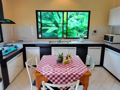 Charming kitchen with lush garden view and cozy dining area