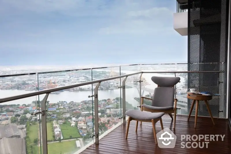 Stunning high-rise balcony with panoramic city and river views, featuring stylish outdoor seating.