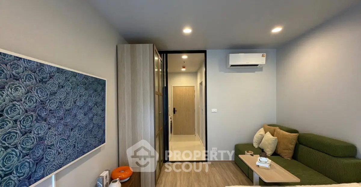 Modern living room with green sofa, air conditioning, and stylish decor in a cozy apartment.