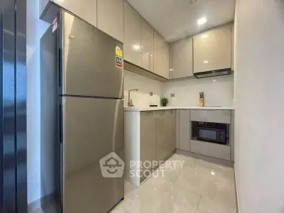 Modern kitchen with sleek cabinetry and stainless steel appliances in a compact layout.