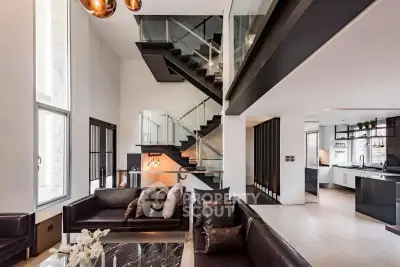Luxurious modern living room with open kitchen and stylish staircase in a contemporary home.