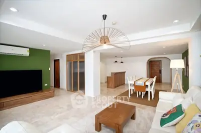 Spacious modern living room with open dining area, stylish lighting, and elegant furniture.