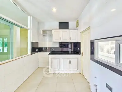 Modern kitchen with sleek white cabinetry and black countertops in a bright, spacious layout.