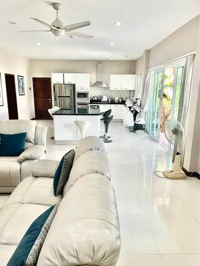 Spacious open-plan living room and kitchen with modern appliances and sleek design.