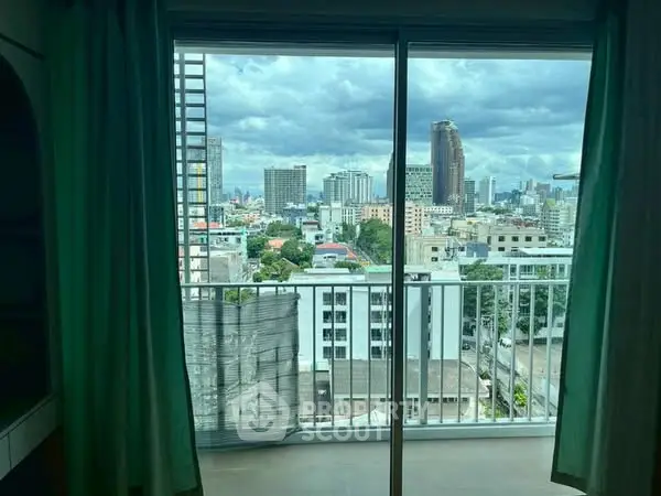 Stunning cityscape view from a high-rise balcony with sliding glass doors.