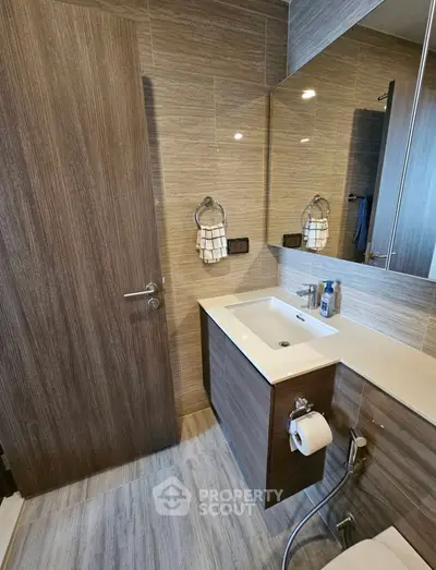 Modern bathroom with sleek wooden cabinetry and contemporary fixtures
