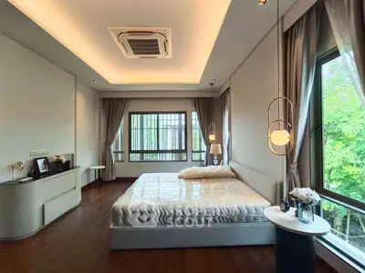 Luxurious bedroom with large windows and elegant lighting in modern home.