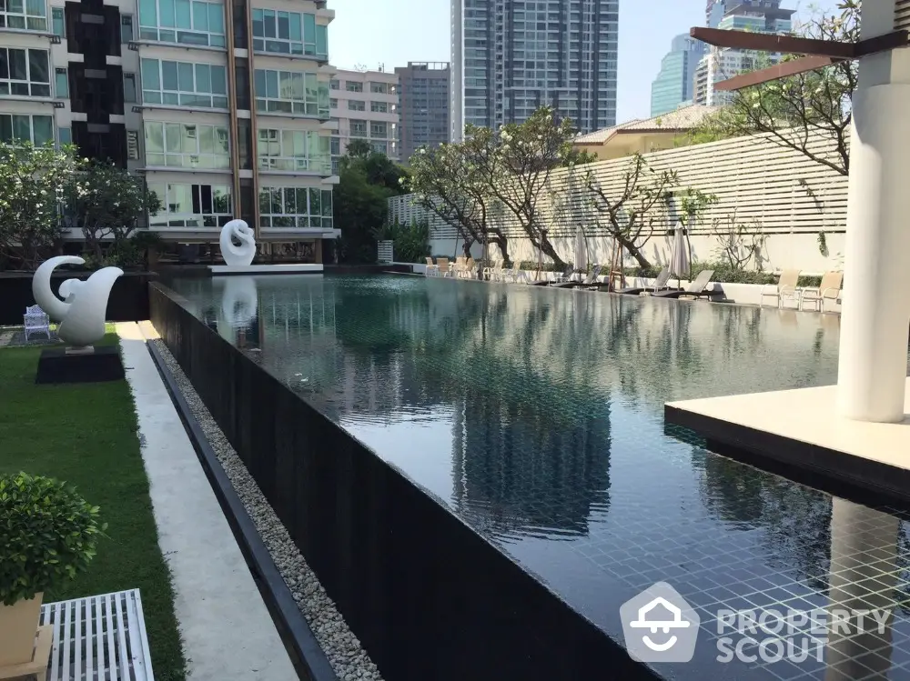 Luxurious condominium with stunning pool and modern architecture in urban setting.