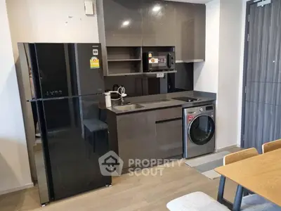 Modern kitchen with sleek appliances including fridge and washing machine, perfect for urban living.