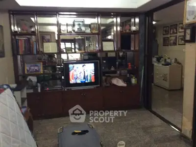 Cozy living room with TV and wall shelving in a residential home