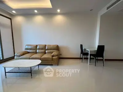 Spacious living room with modern leather sofa and dining area