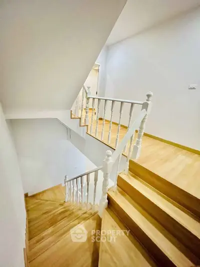 Elegant wooden staircase with white railings in modern home interior