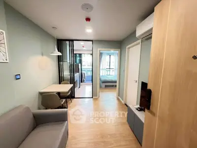 Modern apartment interior with open layout, featuring cozy living area and bedroom view.