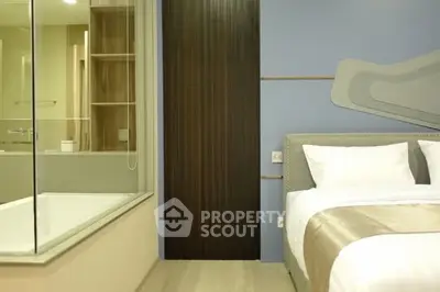 Modern bedroom with adjacent glass-walled bathroom and stylish decor