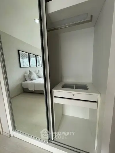 Modern bedroom with mirrored closet and sleek design, perfect for stylish living.