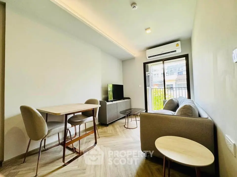 Modern living room with stylish furniture and natural light, featuring a cozy sofa and dining area.