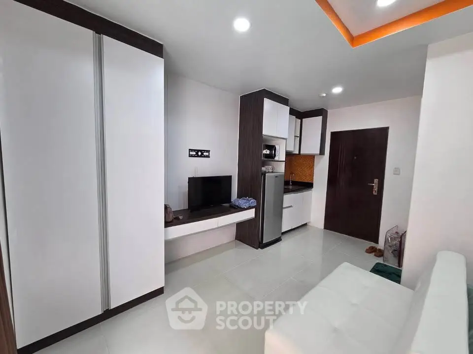 Modern studio apartment with sleek kitchen and cozy living area, perfect for urban living.