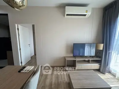 Modern living room with air conditioning and natural light, featuring a sleek TV setup and stylish wooden flooring.