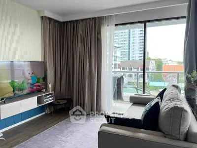 Modern living room with large windows and city view, featuring stylish decor and comfortable seating.