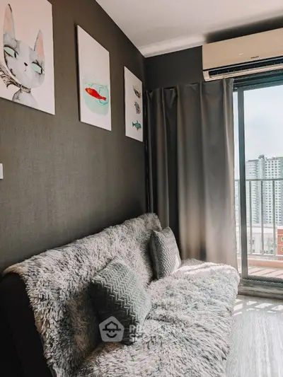 Cozy living room with plush sofa and modern art, featuring city view through large window.