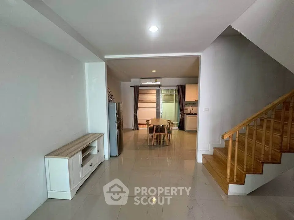 Spacious open-plan living area with modern kitchen and wooden staircase